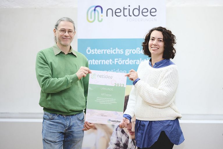 A man and a woman are holding a certificate in their hands