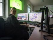 Eine Frau sitzt vor zwei Computerbildschirmen, die eine digitale Anwendung des Bundesheers zeigen.