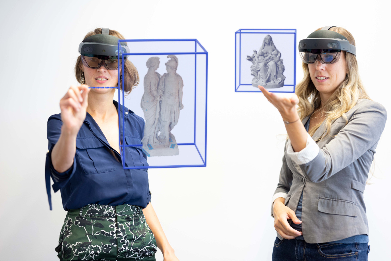 Two women wearing Hololens glasses can be seen, as well as visualizations of what they see in extended reality.