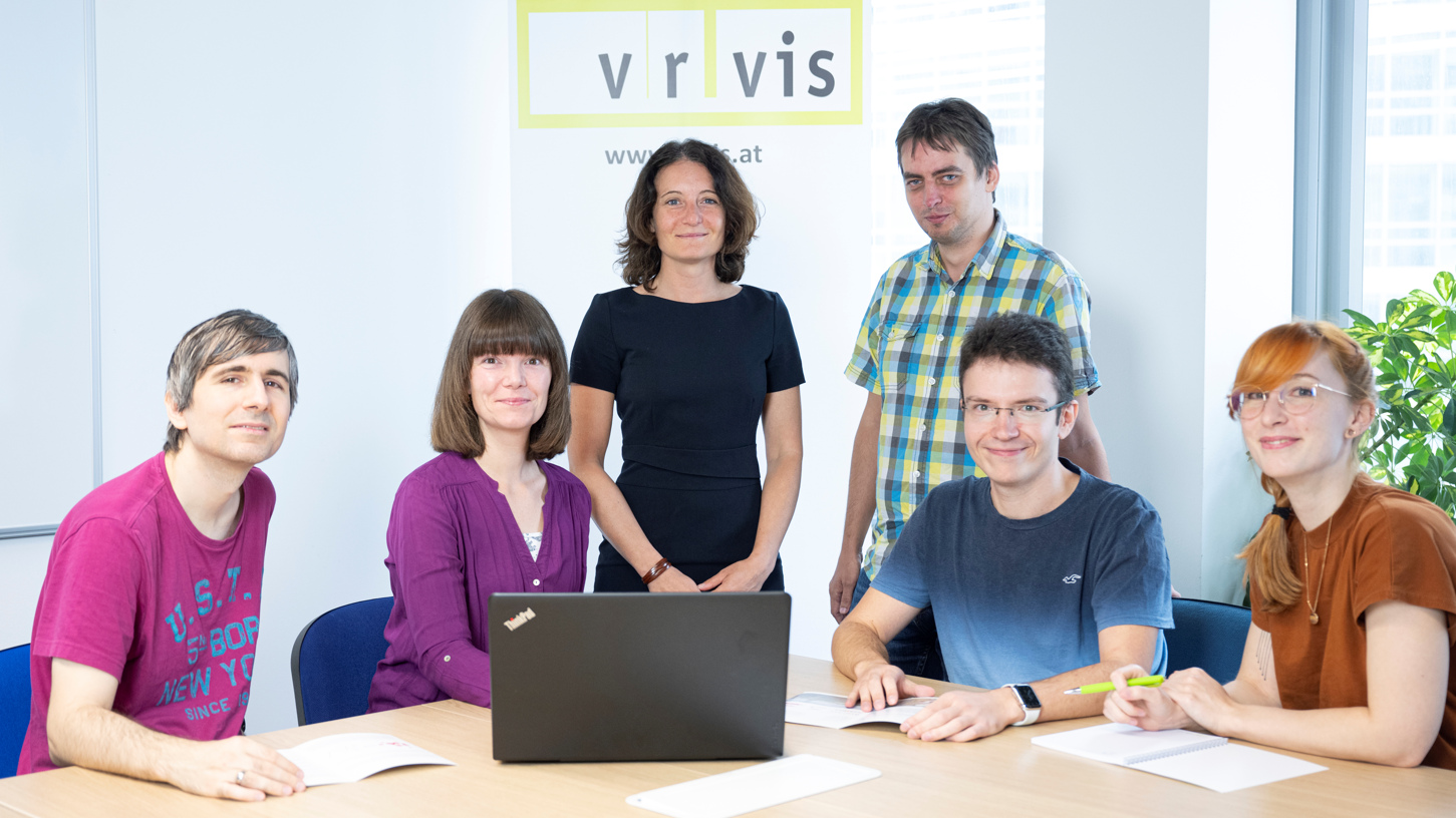 Die Forscherinnen und Forscher der Visual Analyticsforschungsgruppe mit Laptop und VRVis-Banner