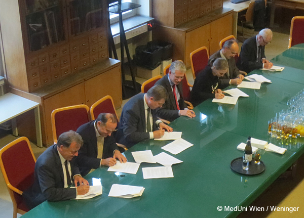 Eine Reihe an Herren an einem Tisch, die den Konsortialvertrag der neuen Plattform unterfertigen.