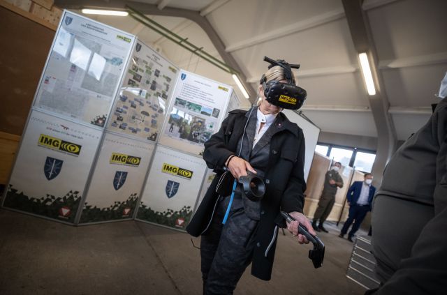 Eine Frau trägt eine Virtual Reality-Brille und bewegt sich in einer virtuellen Umgebung.