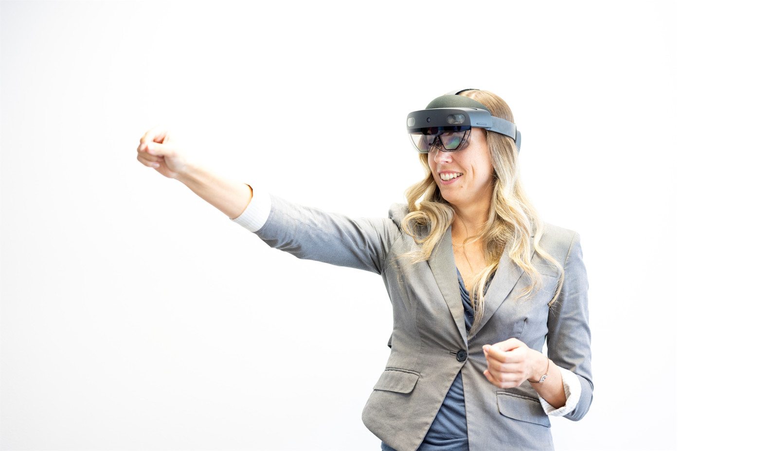 Forscherin mit Augmented Reality-Brille zeigt mit deResearcher wearing augmented reality glasses points her index finger to the left.m Zeigefinger nach links