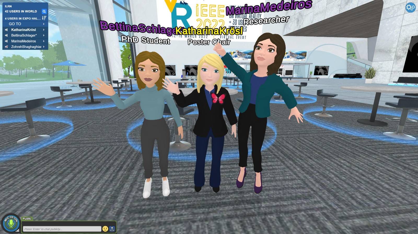Screenshot from Virbela: The avatars of three female researchers are waving with their hands.