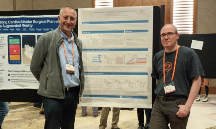 Zwei Männer stehen vor einem Poster bei einer wissenschaftlichen Konferenz.