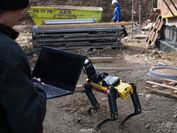 VRVis-Forscher mit Laptop und Roboterhund Spot auf einer Baustelle