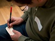 Ein Mann notiert etwas auf einem Zettel.