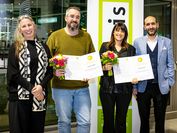 Two award winners with flowers and award certificate in the middle, on the right and on the left the scientific and management of VRVis