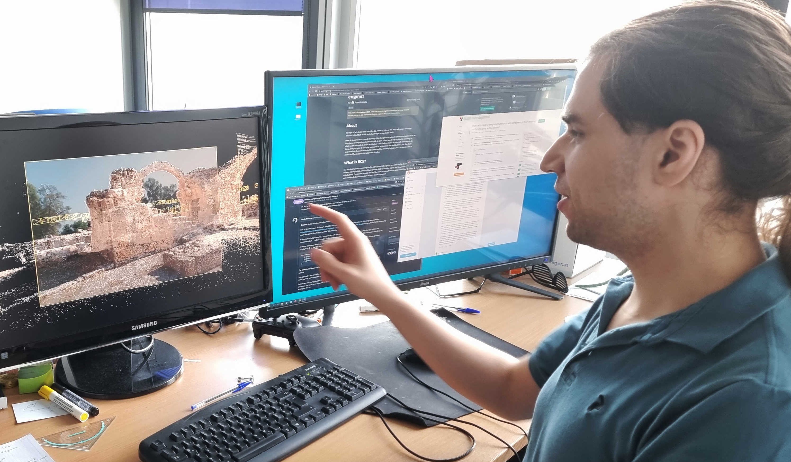 A researcher points to his monitor, which shows a point-cloud reconstruction. 