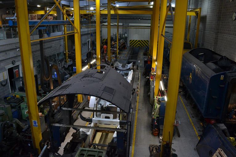 A high and large factory hall where train cars are maintained.