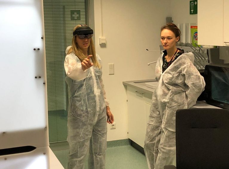 Two female researchers in lab suits in a laboratory.