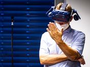 A man wears virtual reality gear and holds his hand in front of his face.
