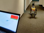 Ein Laptop mit einem großen Stop-Feld und rechts davon ein gelber Roboterhund von hinten, wie er den langen Gang des VRVis-Büros entlang läuft. 