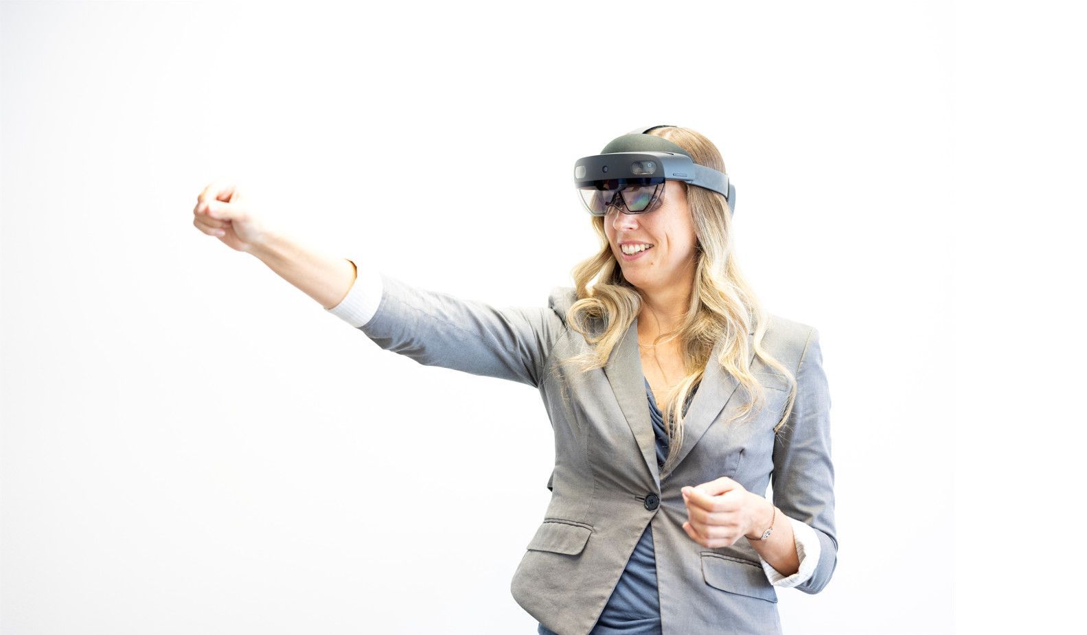 Forscherin mit Augmented Reality-Brille zeigt mit deResearcher wearing augmented reality glasses points her index finger to the left.m Zeigefinger nach links
