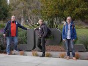 Drei Forscher vor dem Eingangsschild von JPL am NASA-Gelände