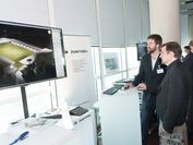 Ein Mitarbeiter des VRVis stellt bei der Leistungsschau ein aktuelles Projekt zur Lichtsimulation vor: zwei Männer schauen auf einen Bildschirm.
