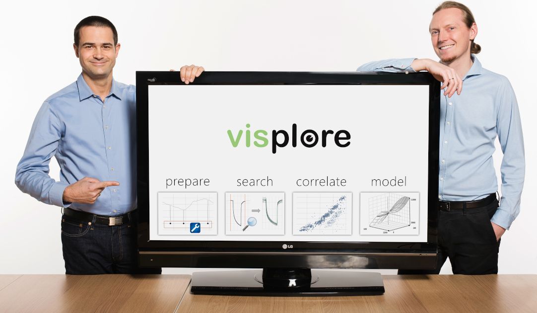 Zwei Männer stehen neben einem großen Monitor, auf dem das Visplore-Logo zu sehen ist.