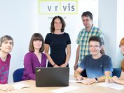 Die Forscherinnen und Forscher der Visual Analyticsforschungsgruppe mit Laptop und VRVis-Banner